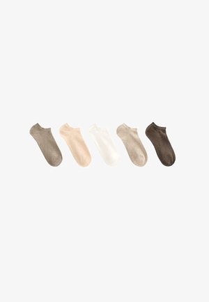 Paar nackte Beine mit hellbeigen, niedrig geschnittenen Knöchelsocken auf weißem Hintergrund.