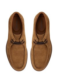 Bottines en daim marron à enfiler avec un bout arrondi, dotées de lacets et de coutures contrastants en marron foncé. Doublure en cuir et semelle texturée.