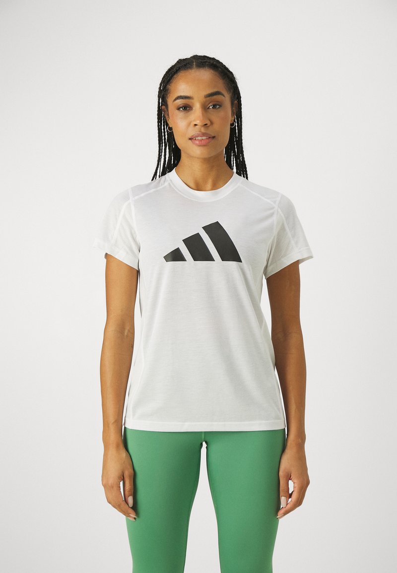 Hvid atletisk t-shirt med et stort sort Adidas-logo på brystet, med korte ærmer og rund halsudskæring.