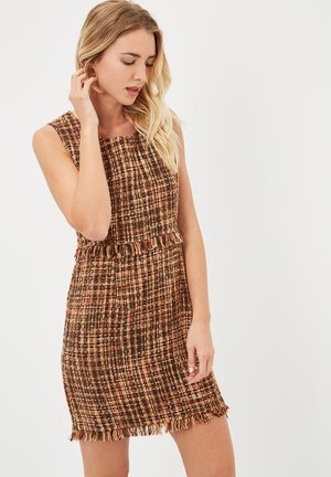 Vestido de tweed marrón y naranja con escote cuadrado, diseño sin mangas, dobladillo con flecos y tela texturizada en un patrón de cuadros.