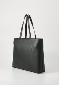 Borsa tote nera in pelle con una superficie liscia, forma rettangolare, due manici della lunghezza delle spalle e una tasca frontale con dettagli di cucitura minimi.