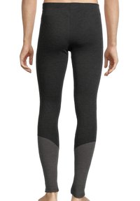 Leggings noirs en tissu extensible, avec une texture lisse et des panneaux gris foncé contrastants au bas de la jambe.
