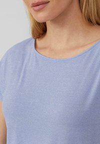 Lichtblauwe t-shirt gemaakt van een zachte, glanzende stof; heeft een ronde halslijn en korte mouwen met een gladde textuur.