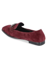 Bordeaux-farbene Wildleder Slipper mit abgerundetem Zeh, einer flachen schwarzen Sohle und einer dekorativen silbernen Schnalle auf dem vorderen Klappenteil. Insgesamt glatte Textur.