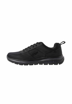 Zwarte lichte sneaker met mesh bovenwerk, vetersluiting, trek-tab aan de hiel en een getextureerde flexibele zool, zijaanzicht op een witte achtergrond.