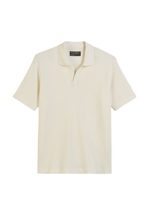 Polo à manches courtes de couleur crème avec un design texturé en côtes et un col classique. Présente une patte de boutonnage étroite et un ourlet cousu.