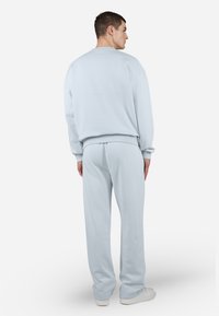 Lyseblå bomulds sweatshirt og sweatpants sæt, med en afslappet pasform, ribbede manchetter og talje, samt en glat tekstur.