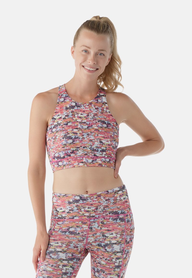 Top corto deportivo multicolor con cuello alto, diseño de espalda de nadador y una tela texturizada y con patrones que presenta acentos en rosa, púrpura y blanco.