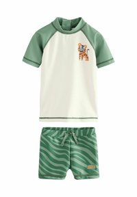 Set da bagno per bambini a due pezzi. Top manica corta bianco e verde con grafica di una tigre; pantaloni corti a righe verdi coordinati. Materiale ad asciugatura rapida.