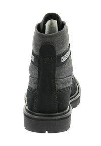 Zwarte en grijze enkelboots met een bovenwerk van suède en stof, gestructureerde patronen, een rubberen zool en een merkaccent op de hak.