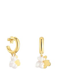 Orecchini a cerchio in oro con un ciondolo a forma di orso bianco e un dettaglio floreale. Il design è liscio con bordi arrotondati e una finitura lucida.