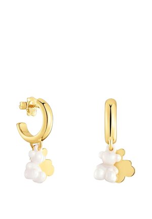 Orecchini a cerchio in oro con un ciondolo a forma di orso bianco e un dettaglio floreale. Il design è liscio con bordi arrotondati e una finitura lucida.