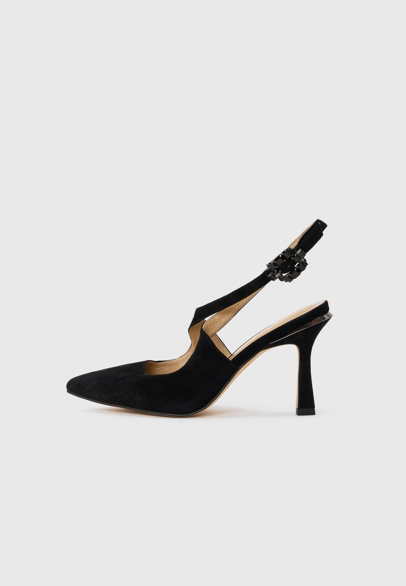 Μαύρο βελούδινο πέδιλο με ψηλό τακούνι, μυτερή μύτη και διακοσμητική αγκράφα στο λουράκι του αστραγάλου, σε πλάγια όψη πάνω σε λευκό φόντο.