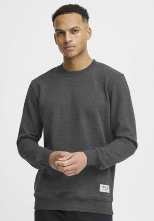 Mørkegrå sweatshirt med rund hals, lange ærmer, ribbede manchetter og kant. Har et lille mærke nederst til venstre. Glat tekstur.