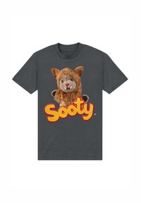 Graues Baumwoll-T-Shirt mit einem Plüschcharakter mit braunem Fell und roter Nase, daneben das Wort "Sooty" in fetten gelben und roten Buchstaben.