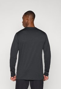 Langarmshirt in Dunkelgrau, aus weichem Stoff gefertigt. Mit Rundhalsausschnitt und nahtlosen Schultern, im lässigen Schnitt und geradem Saum.