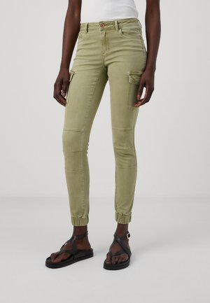 Pantalones cargo verde caqui ajustados, con bolsillos laterales, detalles de estilo cargo y puños elásticos en los tobillos.