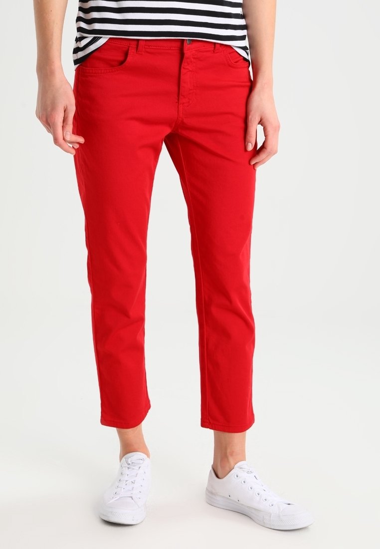 Röda bomullsbyxor med slim fit, kort längd och femficksdesign. Bärs med vita sneakers och en svart-vit randig topp.