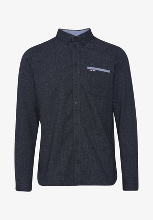 Mørkeblå skjorte med knapper og fin tekstur, lange ermer, og en brystlomme med et stripete design i rødt, hvitt og blått.