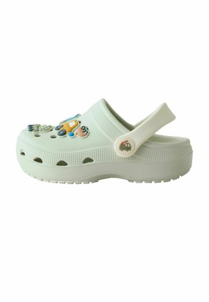 Light green children's clog with adjustable heel strap and colorful vehicle-themed decorations on top.