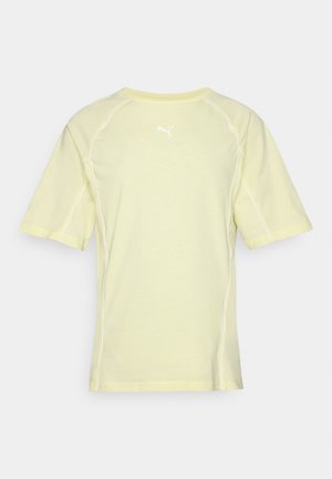 Puma sports t-shirt in light yellow, short sleeves, round neck, with white accent stitching and a small white logo on the upper back.