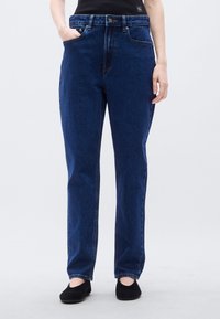 Σκούρο μπλε τζιν παντελόνι με σχεδιασμό ευθείας γραμμής, διαθέτει δύο μπροστινές τσέπες, κλείσιμο με κουμπί και ελαφρύ εφέ ξεθωριάσματος.