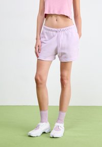 Light purple cotton shorts with an elastic waistband, side pockets, and a drawstring. Paired with white sneakers and light pink ribbed socks.