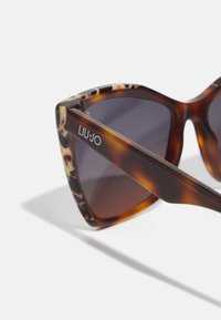 Ochelari de soare Liu Jo cu ramă din material țestoasă, formă unghiulară de cat-eye, lentile întunecate cu degrade și logo argintiu pe braț.