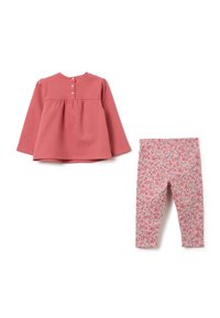 Roze langemouwen top met drie knopen op de achterkant, gecombineerd met roze bloemenprint leggings. Zachte stof, relaxte pasvorm en zachte kleuren.