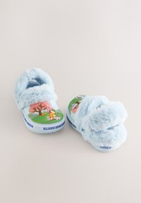 Lyseblå fluffy børneklæder med tegneserie dyr og trætryk på toppen og teksten "Bluey and Bingo" på sålens kanter.