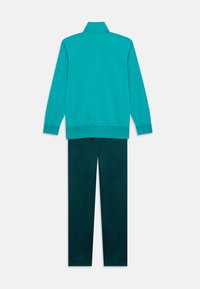 Ensemble de survêtement teal avec une veste à col haut et un pantalon fuselé assorti. Tissu doux avec des détails en bord-côte aux poignets et à la taille.
