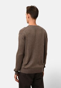 Brauner Wollpullover mit Rundhalsausschnitt, gerippten Bündchen und Saum. Bietet einen lockeren Schnitt mit einer strukturierten Oberfläche. Rückansicht gezeigt.