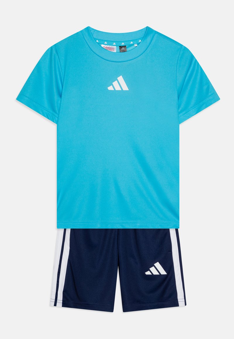 Plava sportska majica kratkih rukava s bijelim logotipom i tamnoplavim šortsem s bijelim bočnim prugama. Lagani, materijal koji odvodi vlagu.