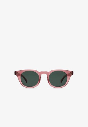 Occhiali da sole con lenti tonde verde scuro e montatura in plastica rosa traslucida, mostrati su sfondo bianco.
