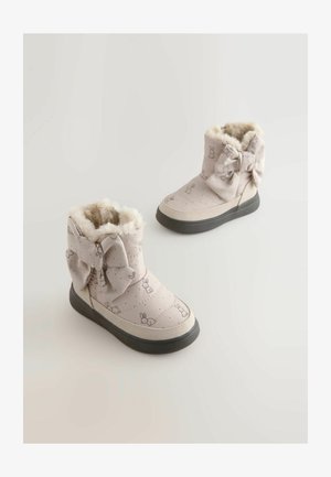 Rozā kvadrātveida potīšu zābaki ar kažokādas oderi, lielu loku sānos un izsmalcinātu zaķa apdruku uz punktainā fona. Gumijas zole.