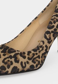 Chaussure à talon haut pour femme avec bout pointu et motif léopard en tons beige, noir et marron.