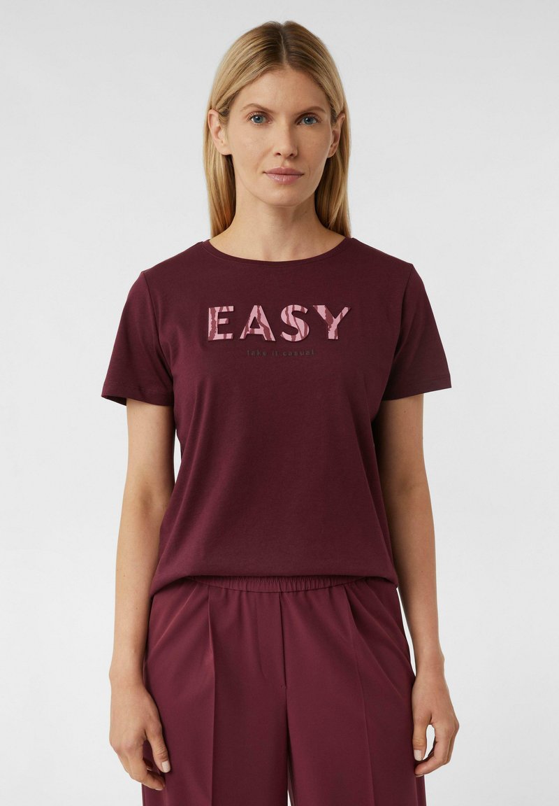 Burgunderfarbendes T-Shirt mit "EASY" Grafik in zartem Rosa, Rundhalsausschnitt, kurzen Ärmeln und weichem Baumwollmaterial, kombiniert mit passenden Hosen.