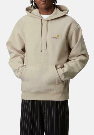 Sudadera con capucha beige hecha de material suave, cuenta con un bolsillo canguro, puños acanalados y un logo bordado en el pecho.