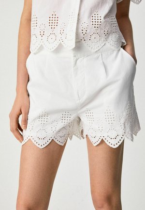 Shorts bianchi in cotone con orlo scallop e dettagli in pizzo ad occhiello. Presentano tasche laterali e una vestibilità comoda e rilassata.