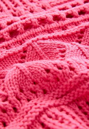 Lys pink stickad tyg med en texturerad mönster av öppna vävningar, som visar en mjuk finish och varierande kabeldesigner.
