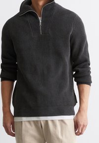 Dunkelgrauer Strickpullover mit halbem Reißverschluss, Rippenstruktur und lässiger Passform. Verfügt über einen kurzen Kragen und seitliche Schlitze für zusätzlichen Komfort.