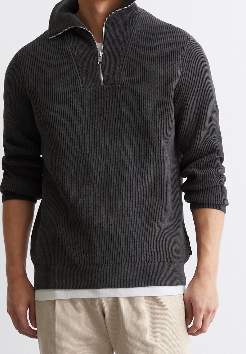 Dunkelgrauer Strickpullover mit halbem Reißverschluss, Rippenstruktur und lässiger Passform. Verfügt über einen kurzen Kragen und seitliche Schlitze für zusätzlichen Komfort.