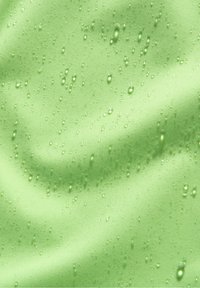 Tissu imperméable vert clair à texture lisse, présentant des gouttelettes d'eau sur sa surface, créant un aspect ondulé.
