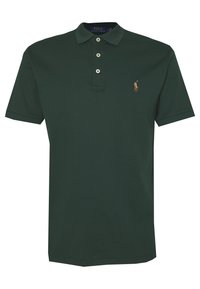 Tmavě zelené polo tričko z bavlny, s límečkem, tříknoflíkovou légou a vyšitým logem na levé části hrudi. Krátké rukávy.