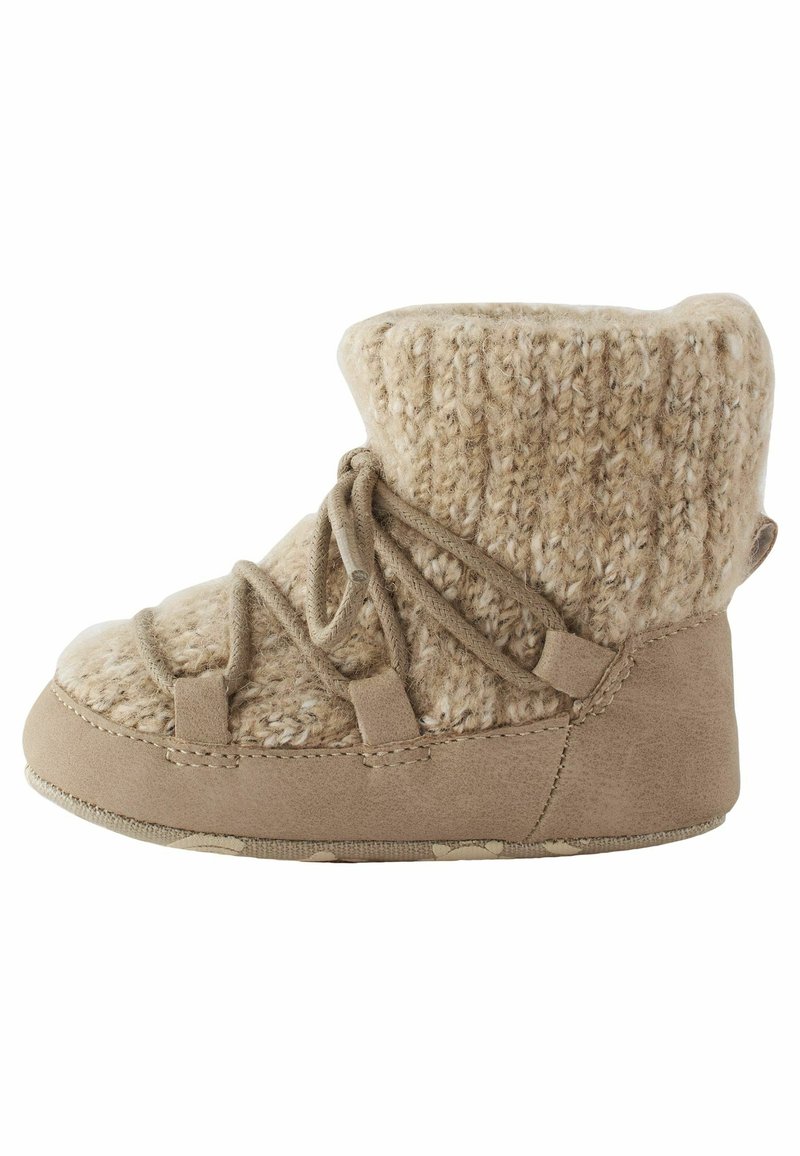 Botte beige douce pour tout-petit avec tige en tricot, semelle en daim et lacets croisés, conçue pour la chaleur et le confort.