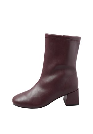 Bordeaux ankelstøvle lavet af glat læder, med rund tå og en kraftig firkantet hæl, samt minimal syning detalje øverst.