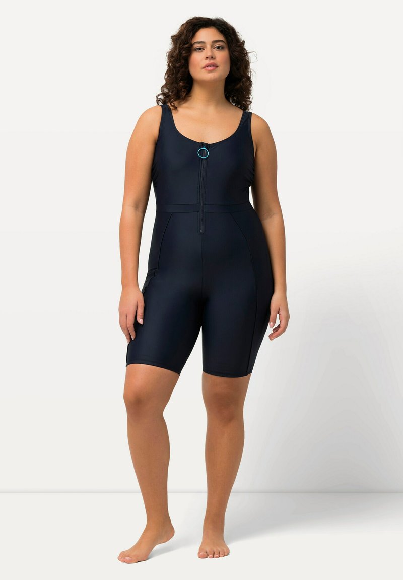 Mörkblå helkroppsvåtdräkt med dragkedja fram, racerback-design och knälånga shorts. Har en liten accentring och sidoficka.