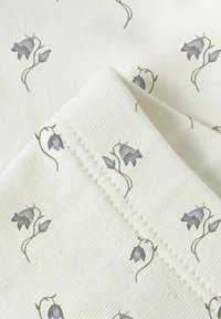 Stof met bloemmotief in licht crèmekleurig met grijze bloemen en groene stelen. Gecorrigeerd oppervlak met een duidelijk geweven afwerking en subtiele stiksel details.