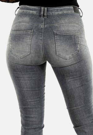 Jeans in denim slim-fit color grigio chiaro, con design a cinque tasche e dettagli cuciti, caratterizzati da una texture leggermente sbiadita.