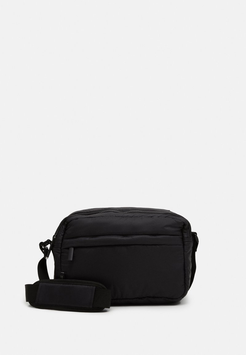 Borsa a tracolla nera imbottita con chiusura a zip, tracolla regolabile e tasca frontale. Texture liscia e forma rettangolare.